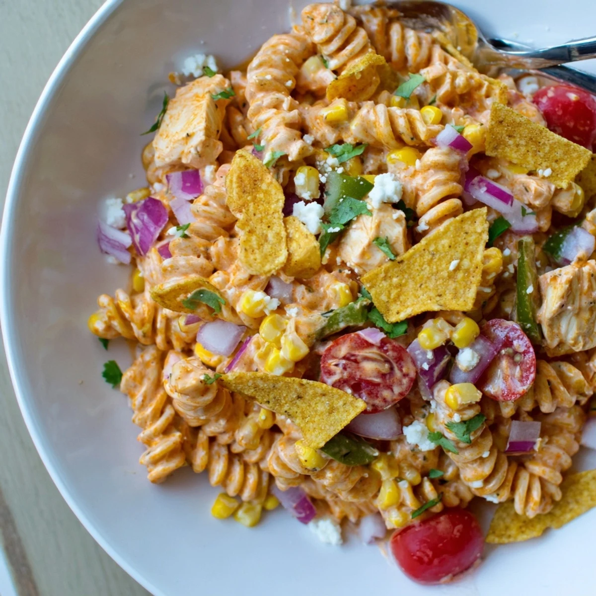 Creamy Mexican street corn chicken pasta salad topped with crunchy crushed tortilla chips